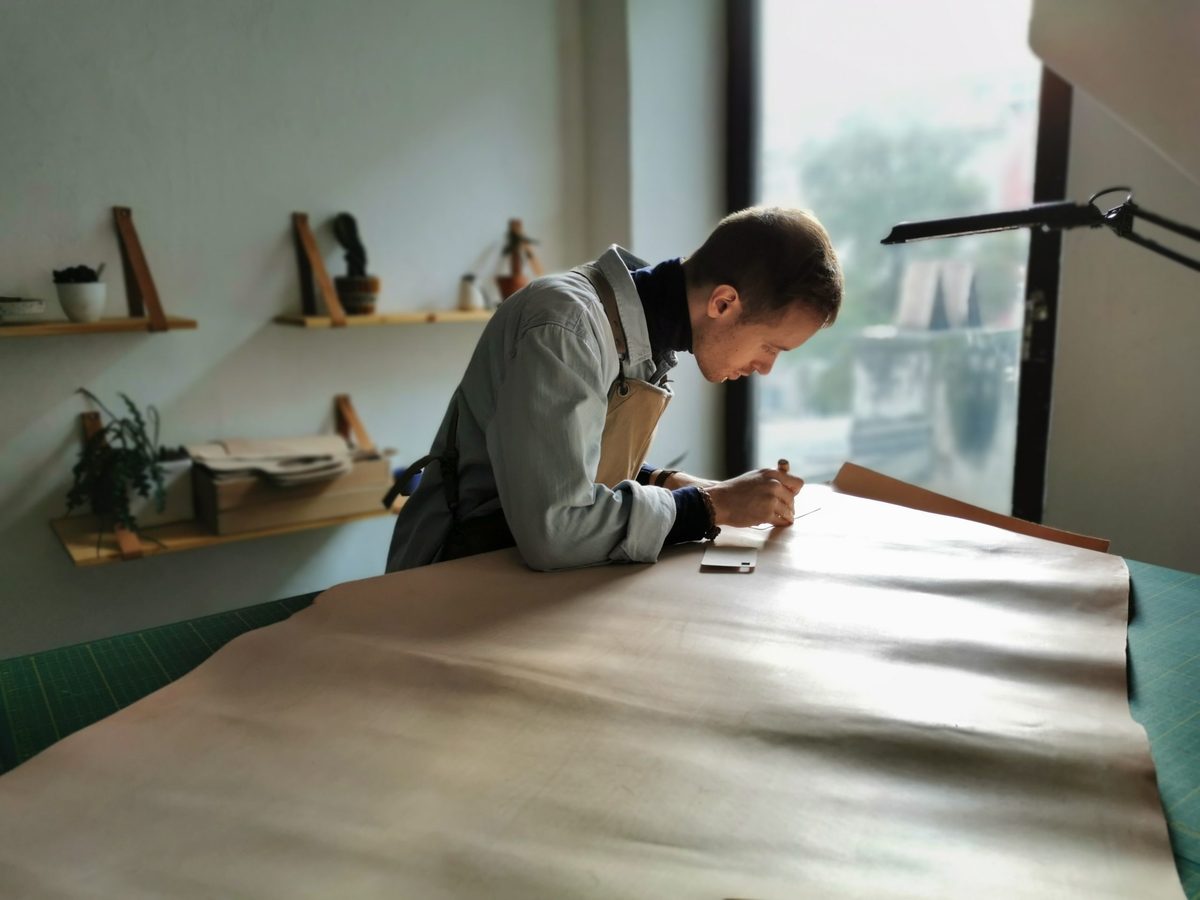 Craftsman cutting full-grain leather hides in the Khushbu workshop
